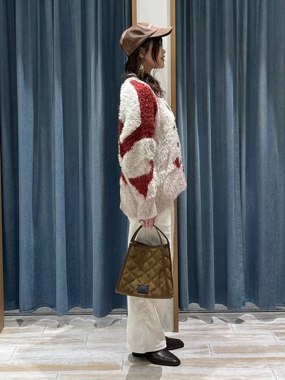 ブラウン系のブーツ、レッド系のカーディガン/ボレロ、イエロー系のハンドバッグを着用したレディースの秋コーディネートの2枚目の写真