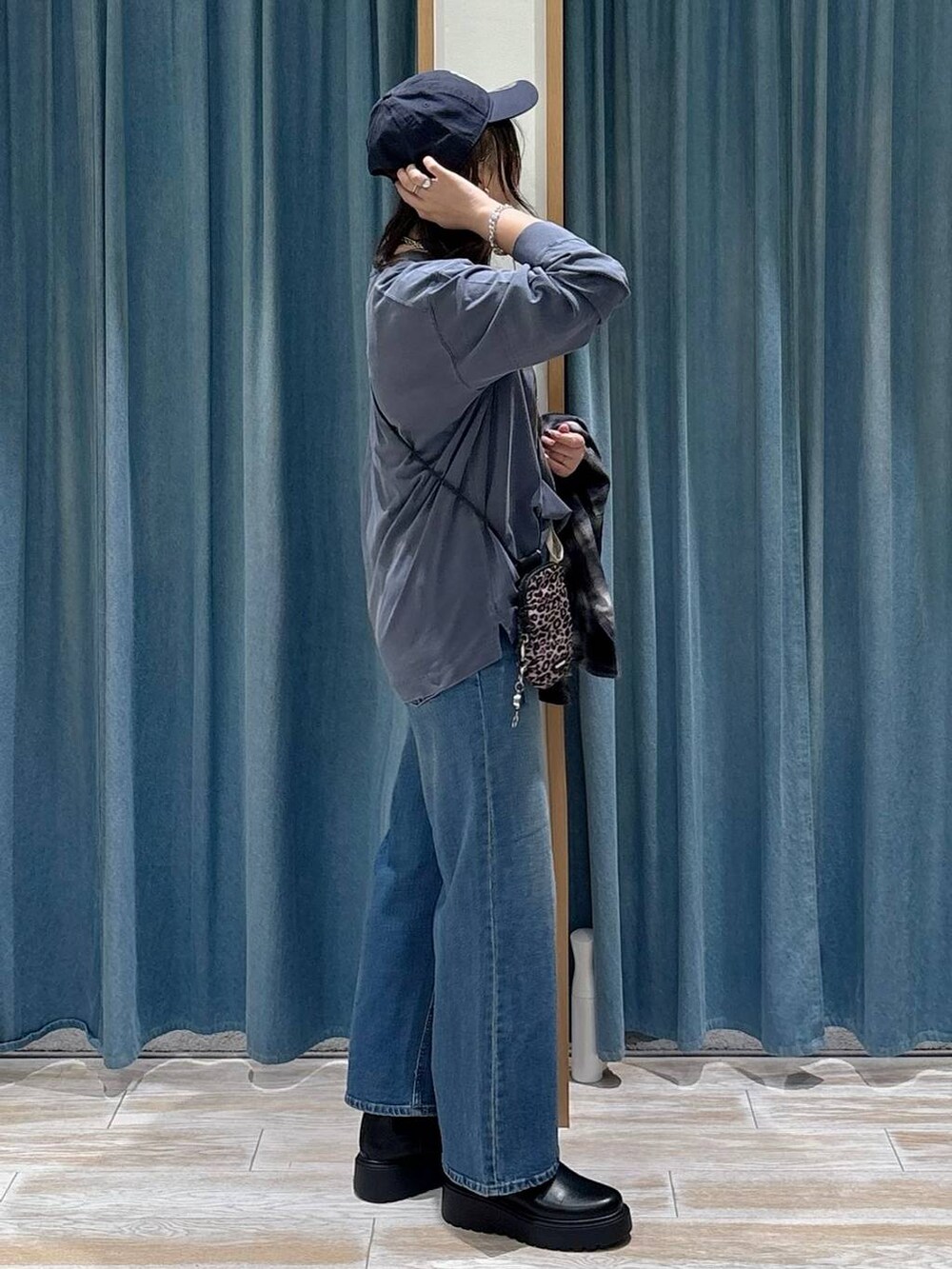 ブラウン系のショルダーバッグ、ブラック系のシャツ/ブラウス、ブルー系のTシャツ/カットソーを着用したレディースの秋コーディネートの2枚目の写真