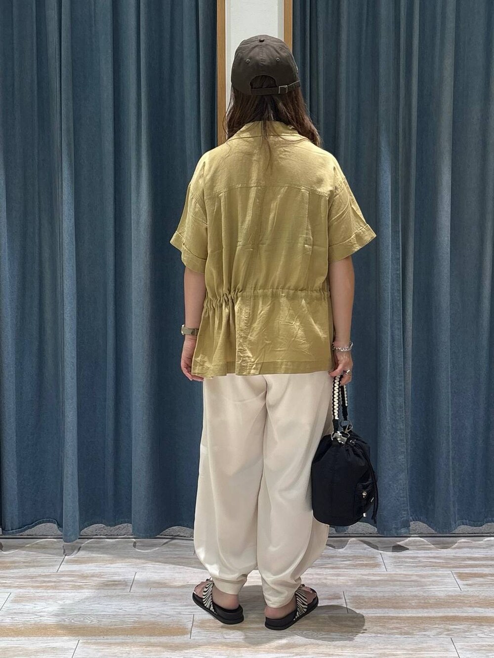 ベージュ系のその他パンツ、イエロー系のシャツ/ブラウス、ブラック系のショルダーバッグを着用したレディースの夏コーディネートの3枚目の写真