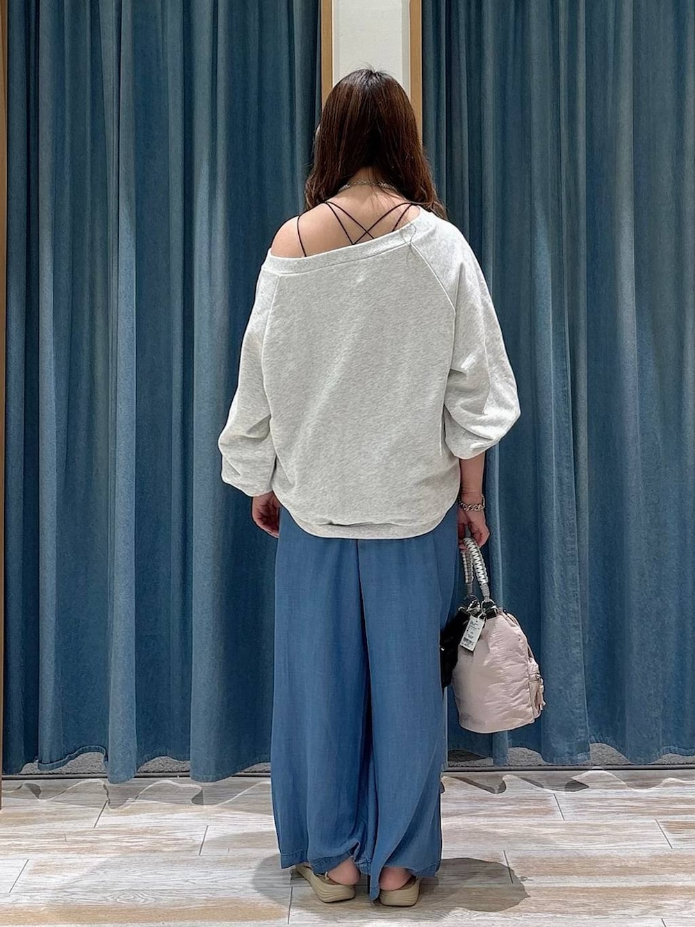 ブルー系のデニムパンツ、グレー系のスウェット、シルバー系のサンダルを着用したレディースの春コーディネートの3枚目の写真
