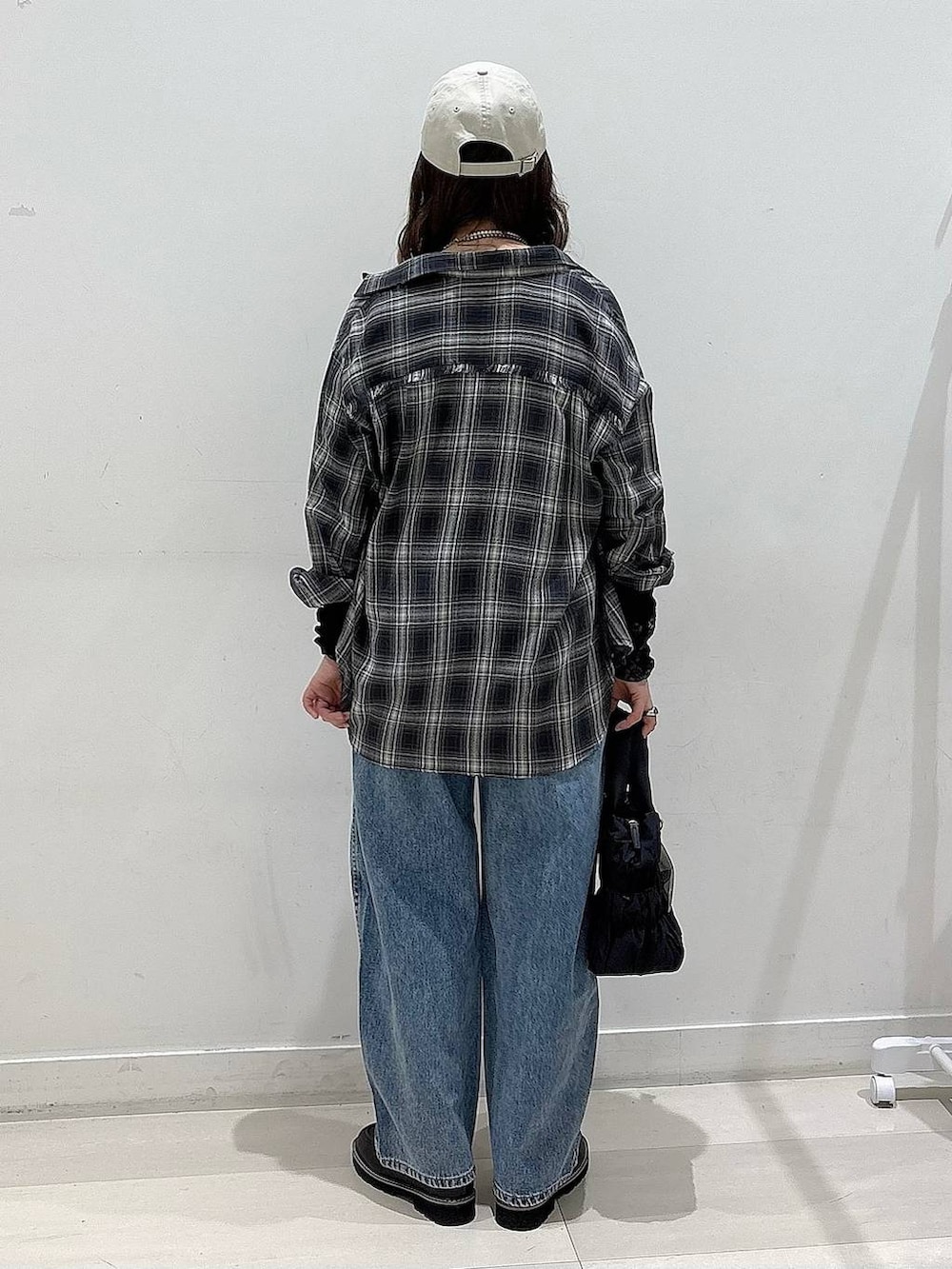 ブラック系のTシャツ/カットソー、ブルー系のデニムパンツ、ブラック系のローファーを着用したレディースの冬コーディネートの3枚目の写真