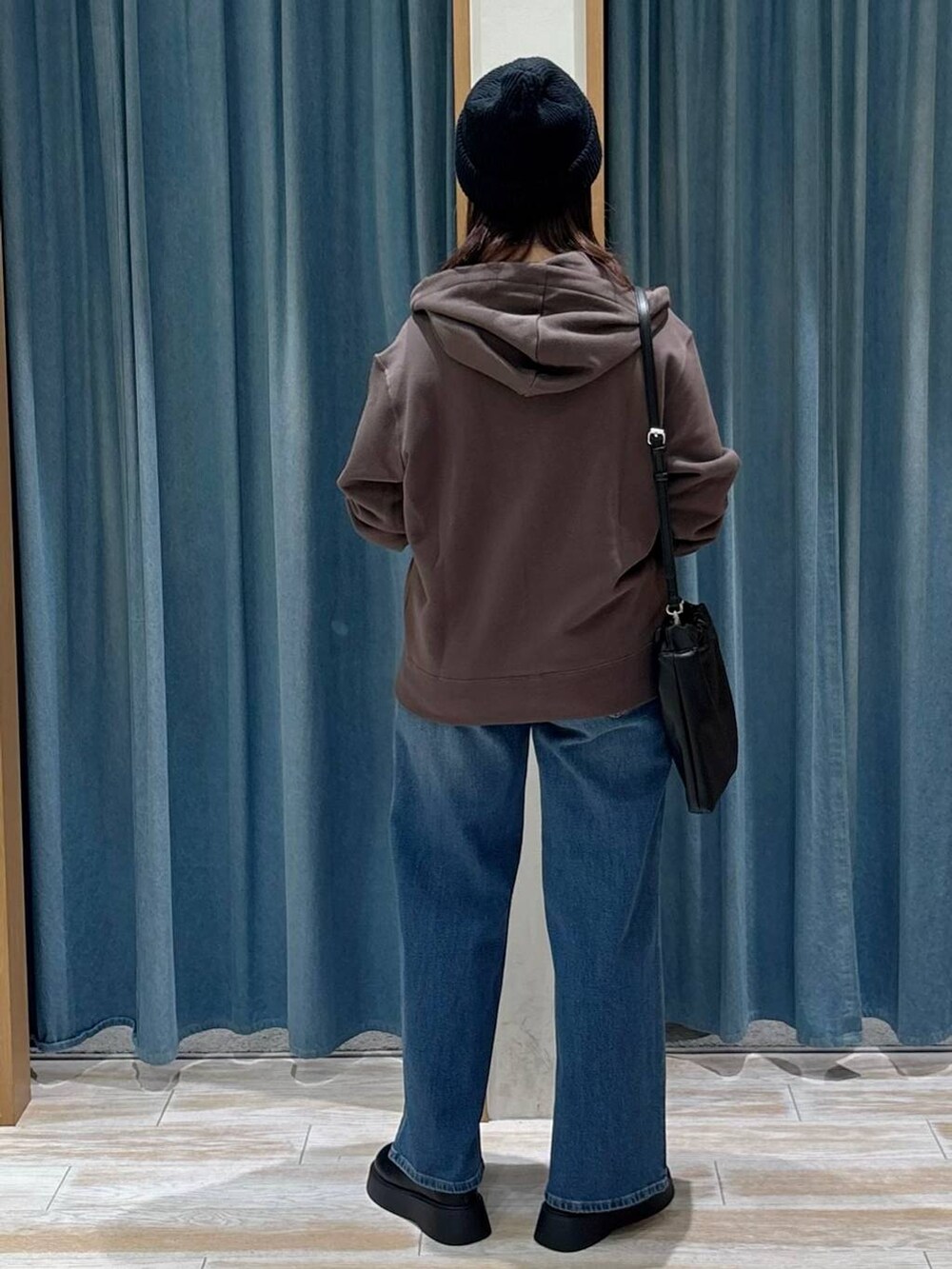 ブラック系のキャミソール、ブラウン系のパーカー、ブラック系のサンダルを着用したレディースの秋コーディネートの3枚目の写真