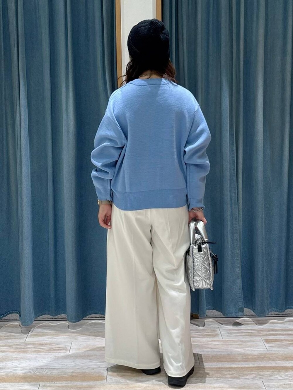 シルバー系のショルダーバッグ、ベージュ系のその他パンツ、ブルー系のニット/セーターを着用したレディースの秋コーディネートの3枚目の写真