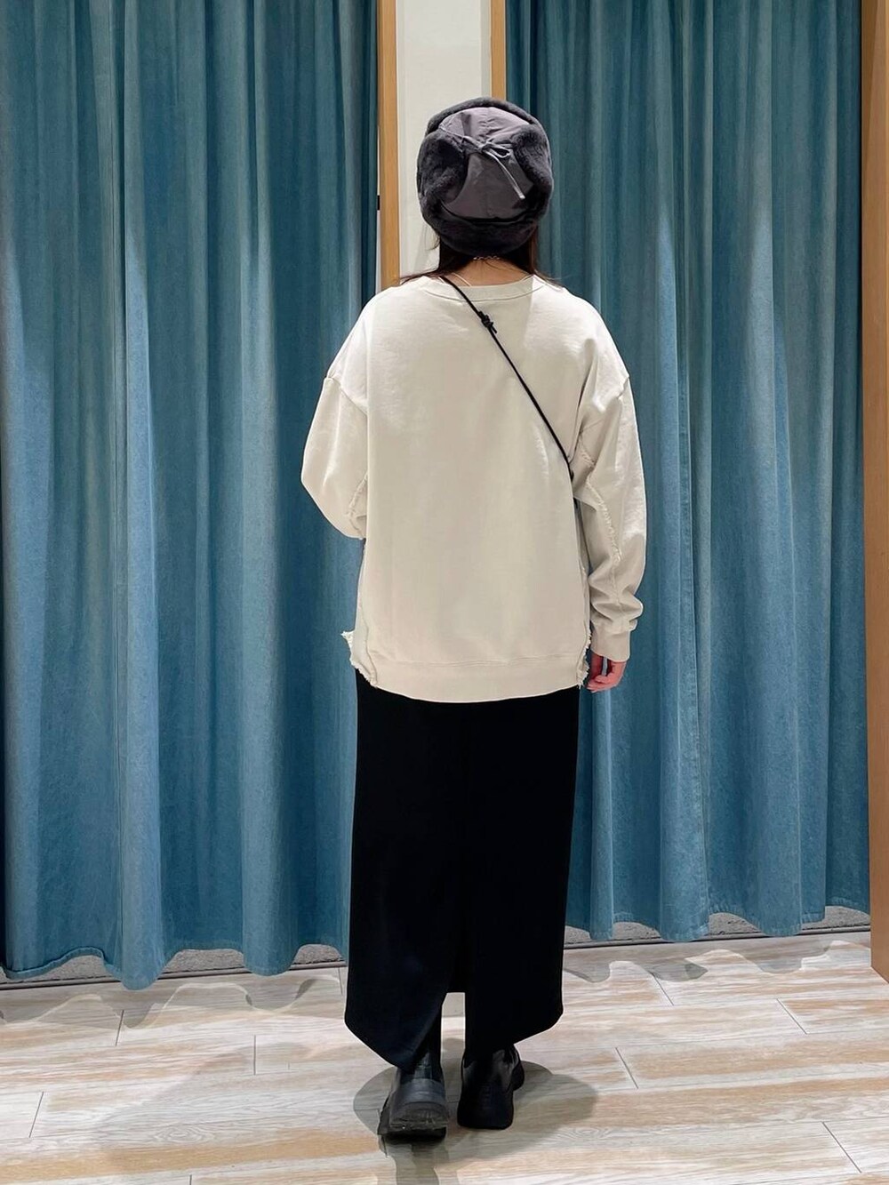 ブラック系のブーツ、ブラウン系のショルダーバッグ、ブラック系のスカートを着用したレディースの冬コーディネートの3枚目の写真