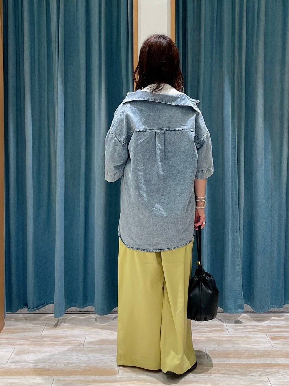 イエロー系のその他パンツ、ブラック系のショルダーバッグ、ホワイト系のTシャツ/カットソーを着用したレディースの春コーディネートの3枚目の写真