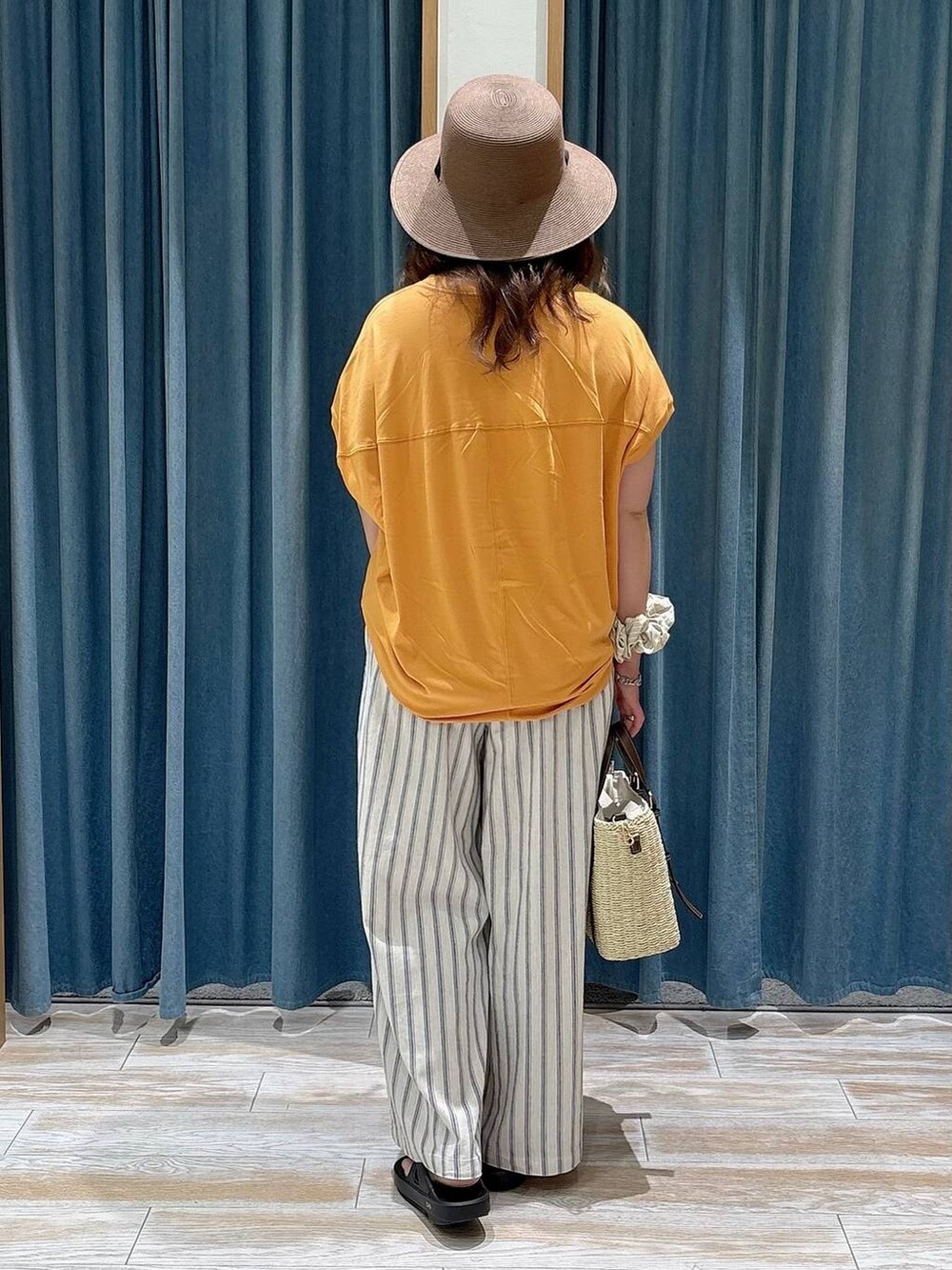 ホワイト系のその他パンツ、ブラウン系のショルダーバッグ、ブラック系のサンダルを着用したレディースの春コーディネートの3枚目の写真