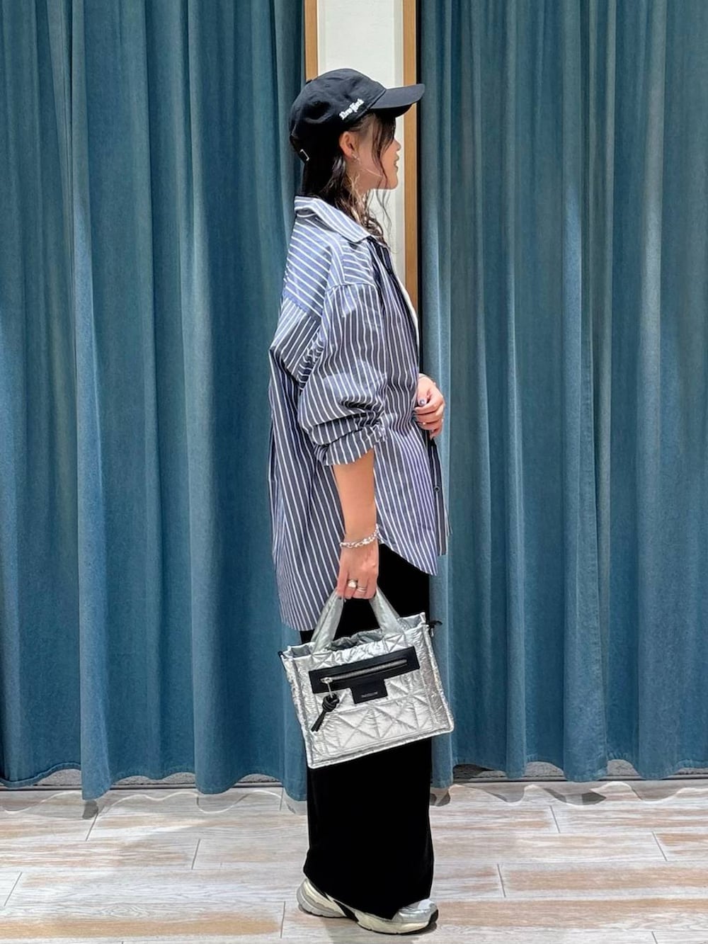 シルバー系のショルダーバッグ、ブルー系のシャツ/ブラウス、ホワイト系のTシャツ/カットソーを着用したレディースの秋コーディネートの2枚目の写真
