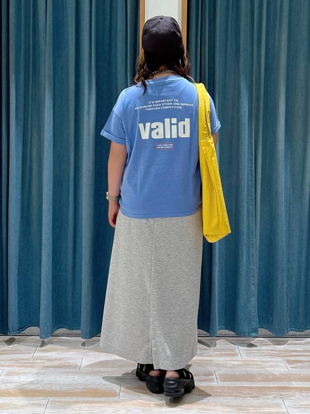 ブルー系のTシャツ/カットソー、イエロー系のトートバッグ、グレー系のスカートを着用したレディースの夏コーディネートの3枚目の写真
