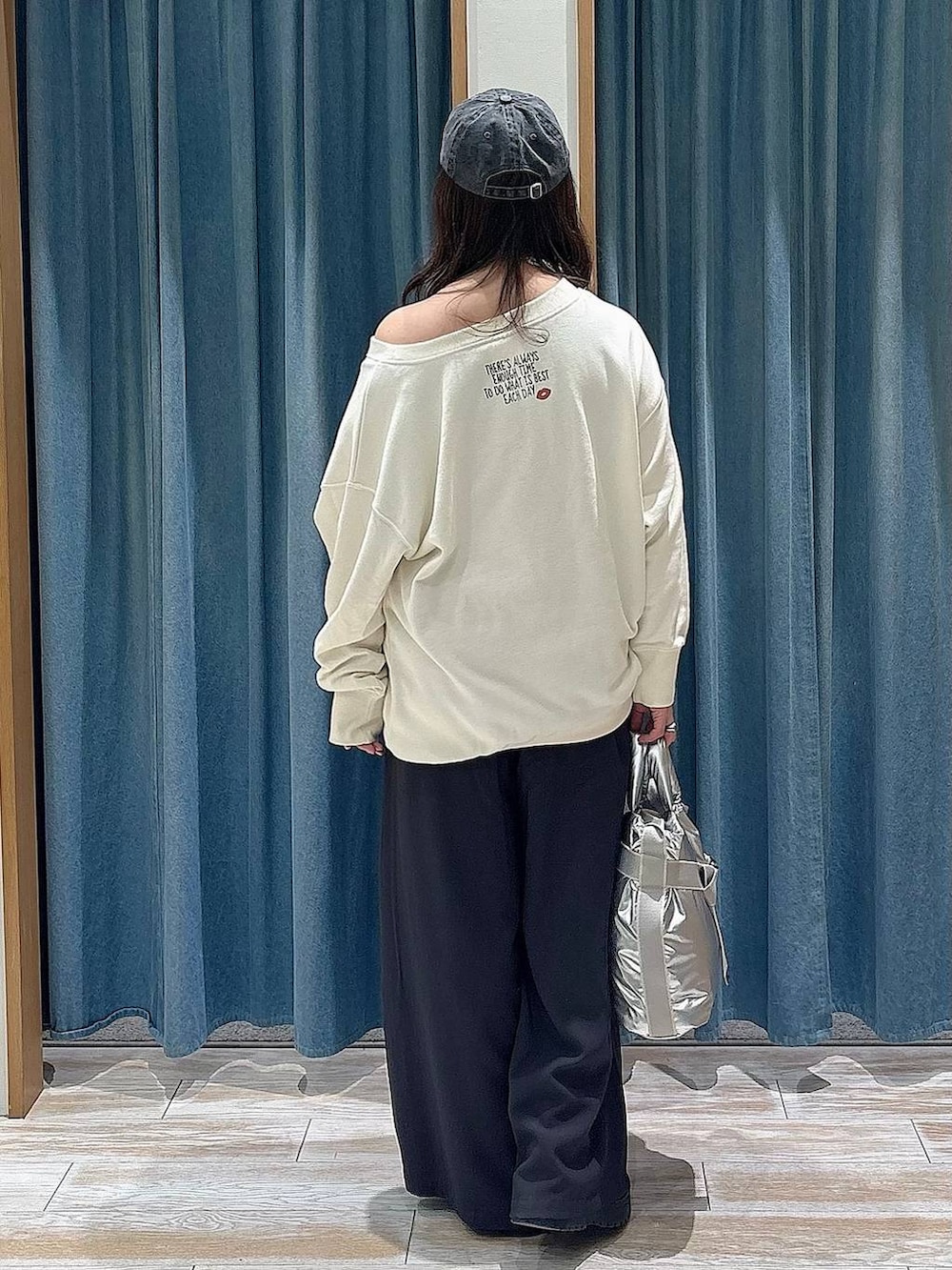 シルバー系のトートバッグ、ブラック系のブーツ、グレー系のその他パンツを着用したレディースの冬コーディネートの3枚目の写真