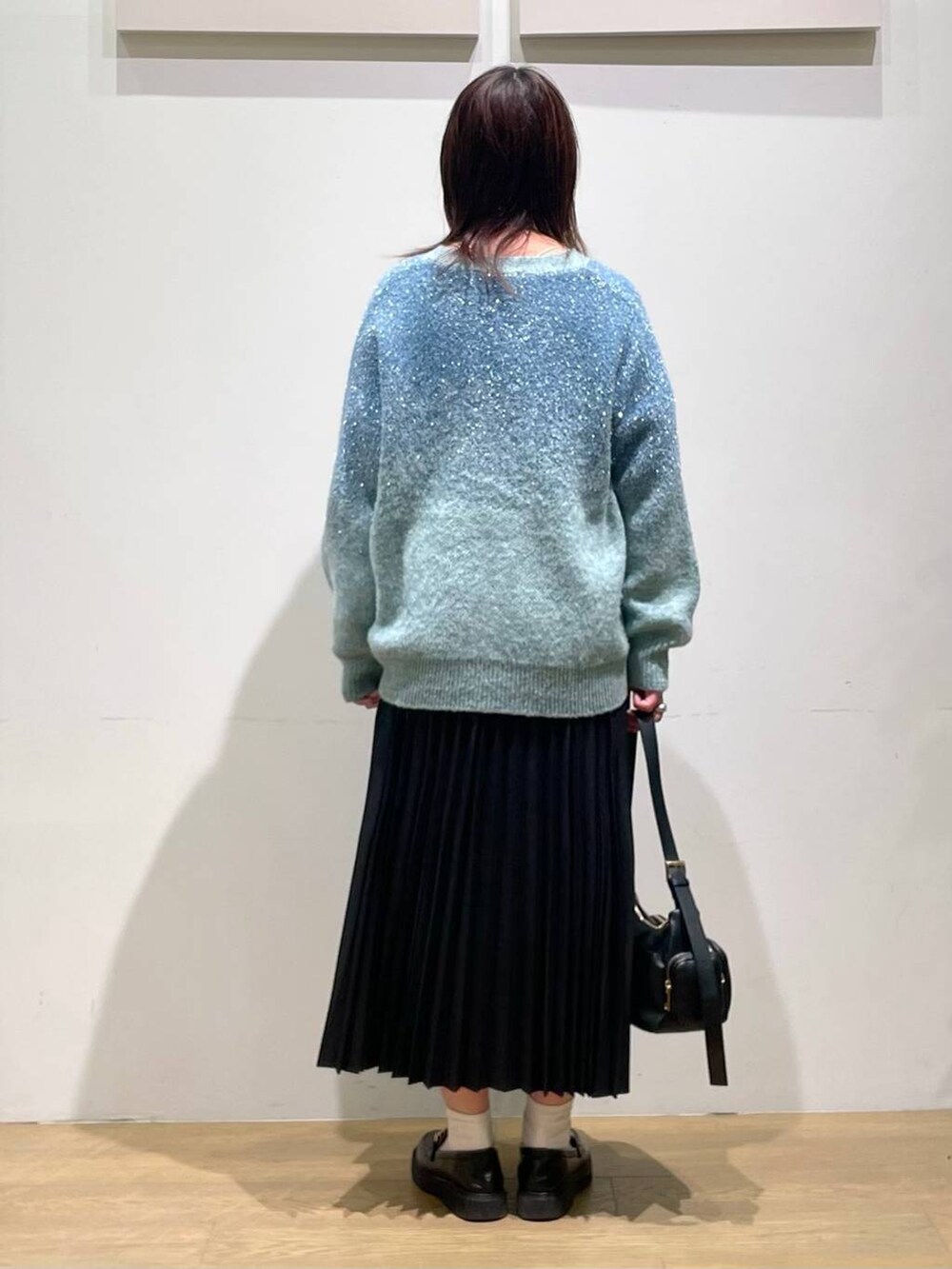 ブラック系のローファー、ブラック系のハンドバッグ、ホワイト系のキャミソールを着用したレディースの秋コーディネートの3枚目の写真