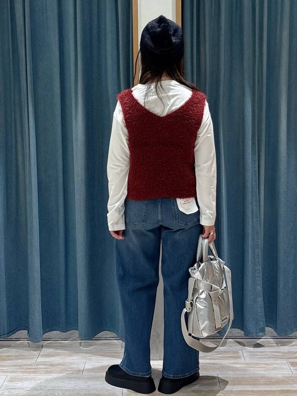 シルバー系のトートバッグ、ホワイト系のTシャツ/カットソー、レッド系のベストを着用したレディースの秋コーディネートの3枚目の写真