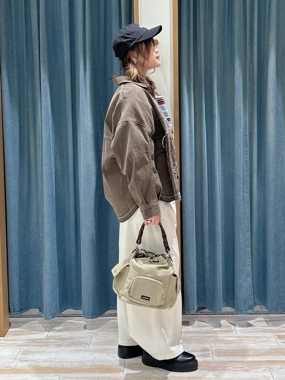 ベージュ系のその他パンツ、ブラック系のブーツ、ベージュ系のハンドバッグを着用したレディースの冬コーディネートの2枚目の写真