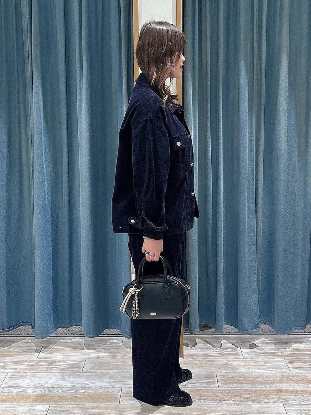 ブラック系のTシャツ/カットソー、ブラック系のローファー、ブラック系のハンドバッグを着用したレディースの冬コーディネートの2枚目の写真