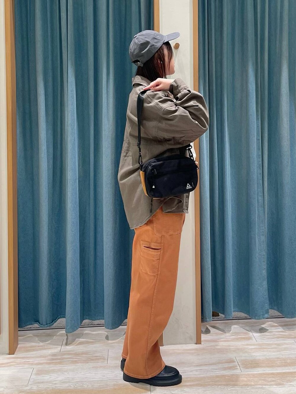 オレンジ系のその他パンツ、その他のローファー、ホワイト系のTシャツ/カットソーを着用したレディースの冬コーディネートの2枚目の写真