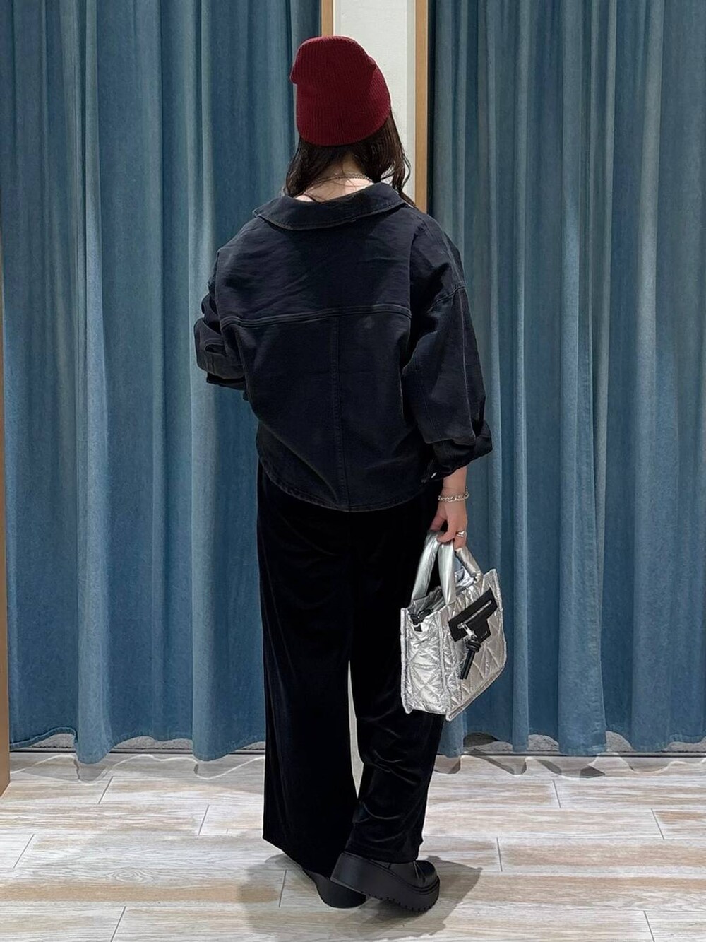 ブラック系のキャミソール、シルバー系のショルダーバッグ、ブラック系のブーツを着用したレディースの秋コーディネートの3枚目の写真