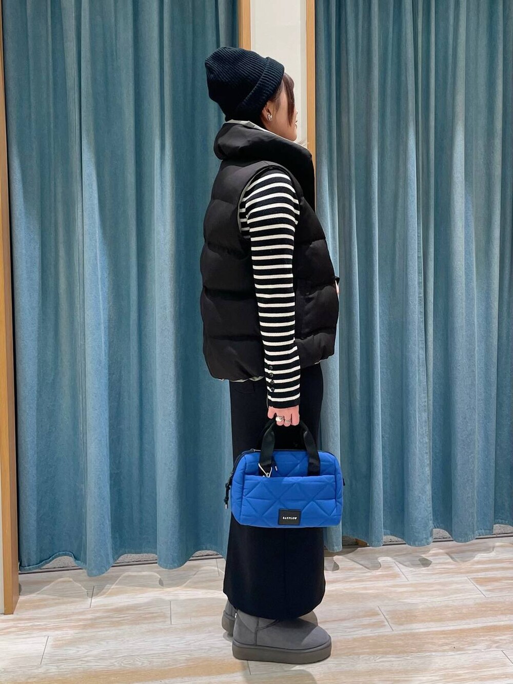 ブラック系のニット/セーター、ブラック系のベスト、グレー系のブーツを着用したレディースの冬コーディネートの2枚目の写真