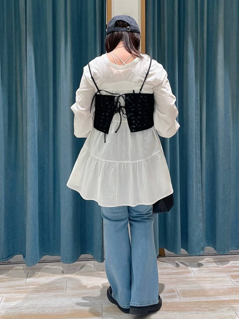 ブルー系のデニムパンツ、ブラック系のキャミソール、ブラック系のハンドバッグを着用したレディースの春コーディネートの3枚目の写真