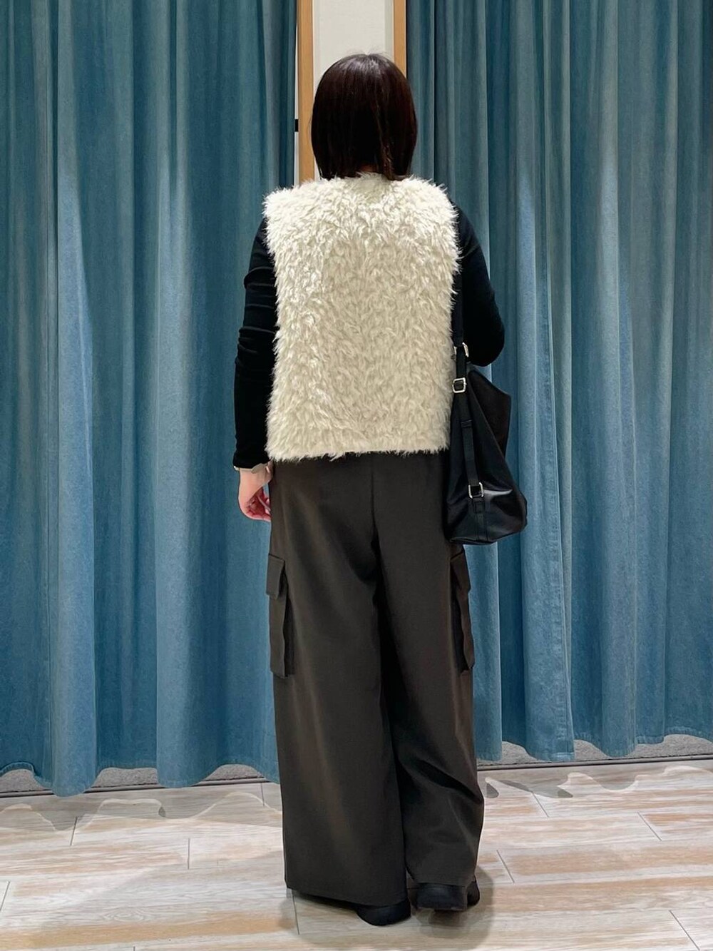 ブラック系のTシャツ/カットソー、ブラック系のブーツ、ブラック系のショルダーバッグを着用したレディースの冬コーディネートの2枚目の写真