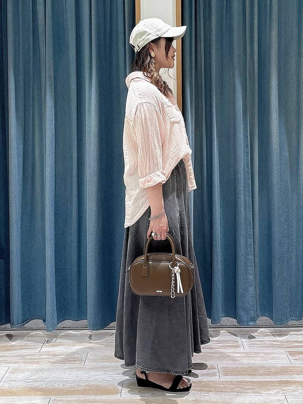 ピンク系のシャツ/ブラウス、ブラウン系のハンドバッグ、ブラック系のサンダルを着用したレディースの春コーディネートの2枚目の写真