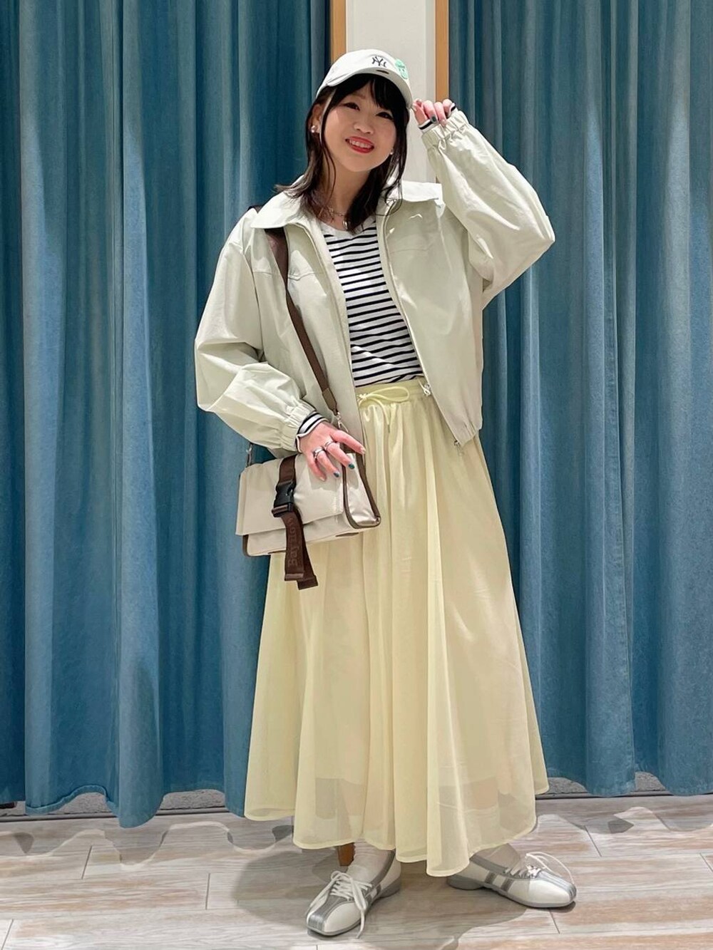 ホワイト系のTシャツ/カットソー、ベージュ系のショルダーバッグ、ホワイト系のスニーカーを着用したレディースの冬コーディネートの4枚目の写真