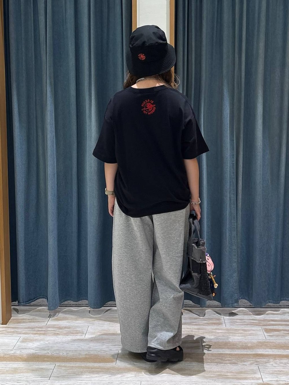 グレー系のスウェットパンツ、ブラック系のトートバッグ、ブラック系のTシャツ/カットソーを着用したレディースの夏コーディネートの3枚目の写真