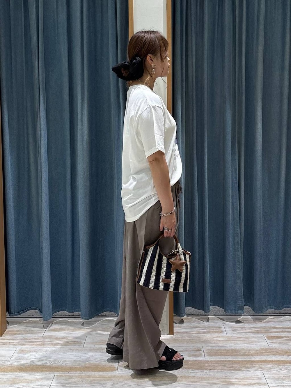 ブラウン系のその他パンツ、ブラック系のショルダーバッグ、ホワイト系のシャツ/ブラウスを着用したレディースの夏コーディネートの2枚目の写真