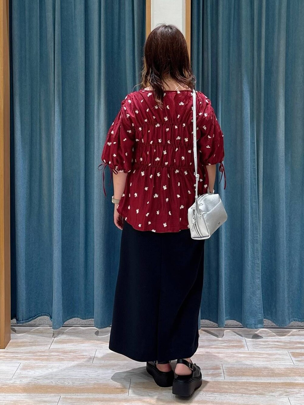 ブラック系のスカート、シルバー系のショルダーバッグ、レッド系のシャツ/ブラウスを着用したレディースの夏コーディネートの3枚目の写真