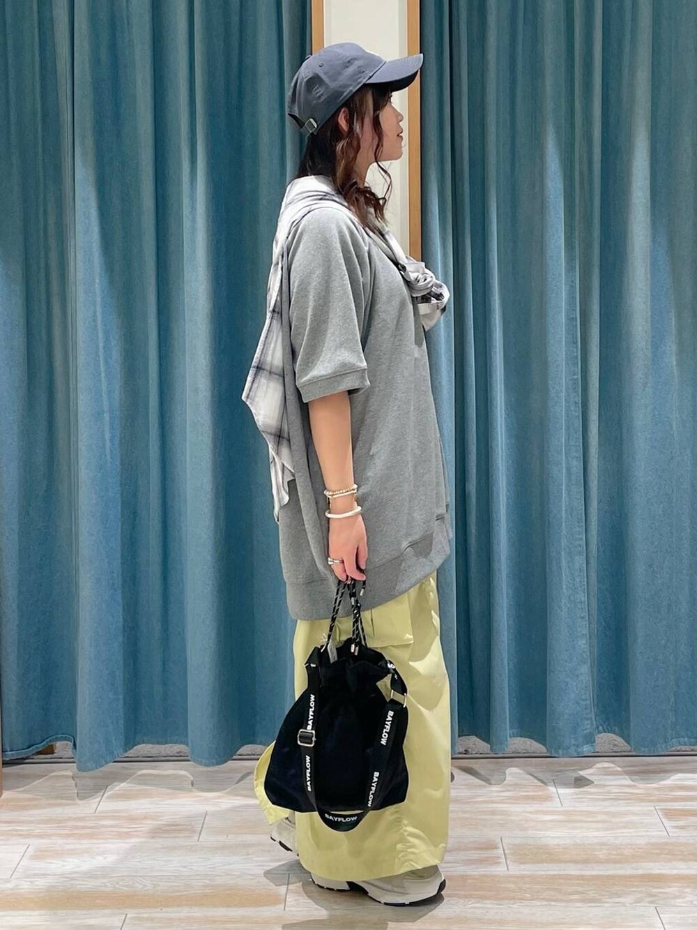 ブラック系のショルダーバッグ、ホワイト系のスニーカー、ホワイト系のシャツ/ブラウスを着用したレディースの春コーディネートの2枚目の写真