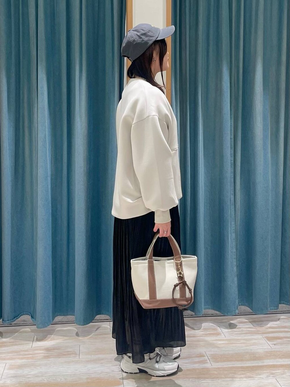 ホワイト系のTシャツ/カットソー、ブラウン系のトートバッグ、ブラック系のスカートを着用したレディースの冬コーディネートの2枚目の写真