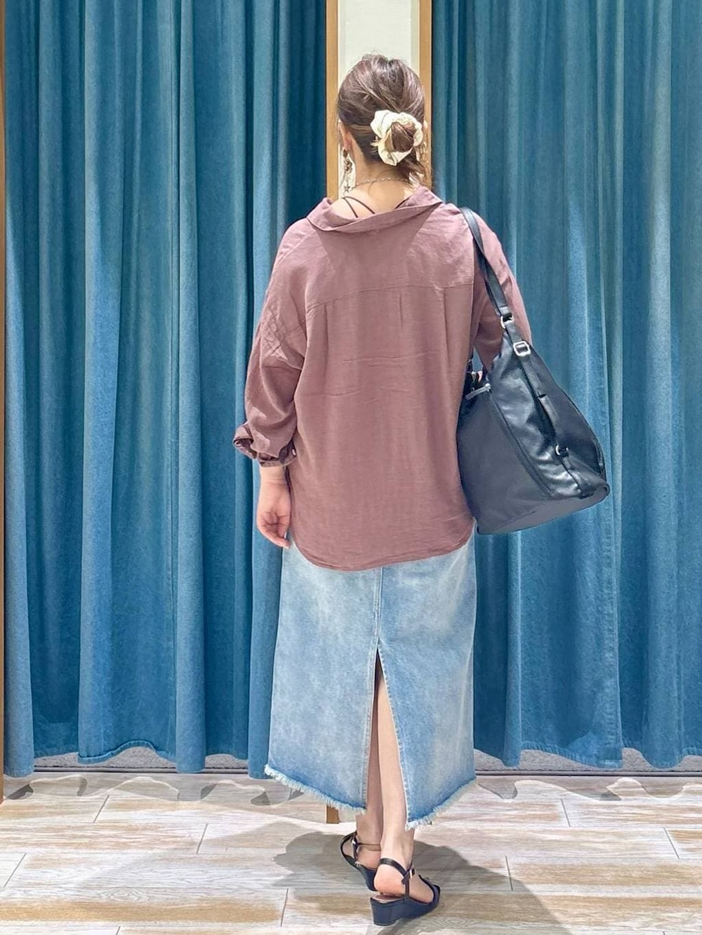 ブラウン系のシャツ/ブラウス、ブルー系のデニムスカート、ブラック系のトートバッグを着用したレディースの春コーディネートの3枚目の写真