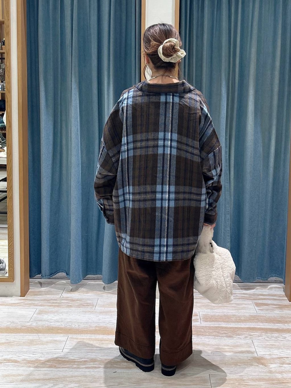 ブラウン系のその他パンツ、ベージュ系のハンドバッグ、ホワイト系のベストを着用したレディースの秋コーディネートの3枚目の写真