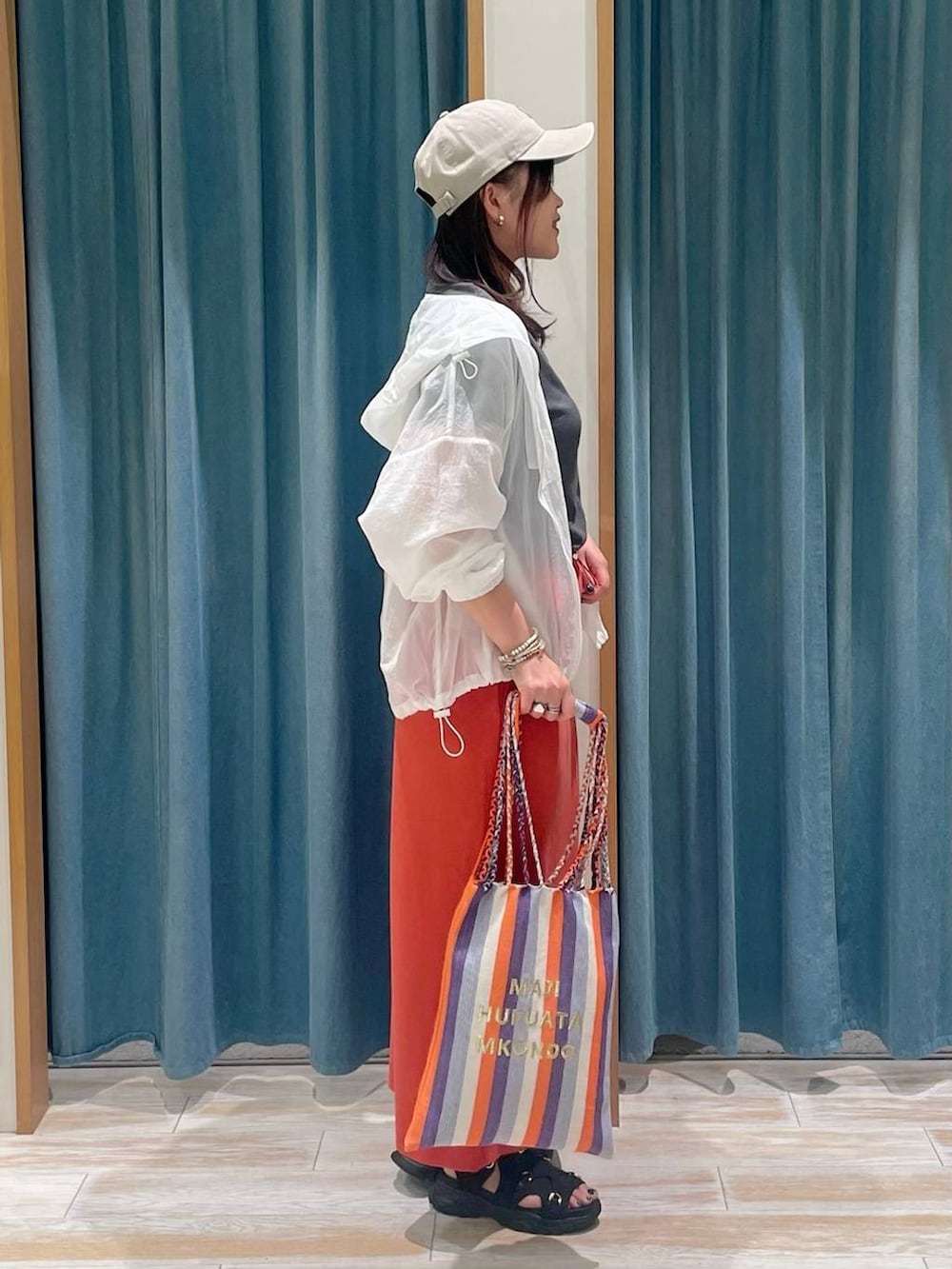 グレー系のTシャツ/カットソー、パープル系のトートバッグ、ホワイト系のナイロンジャケットを着用したレディースの春コーディネートの2枚目の写真