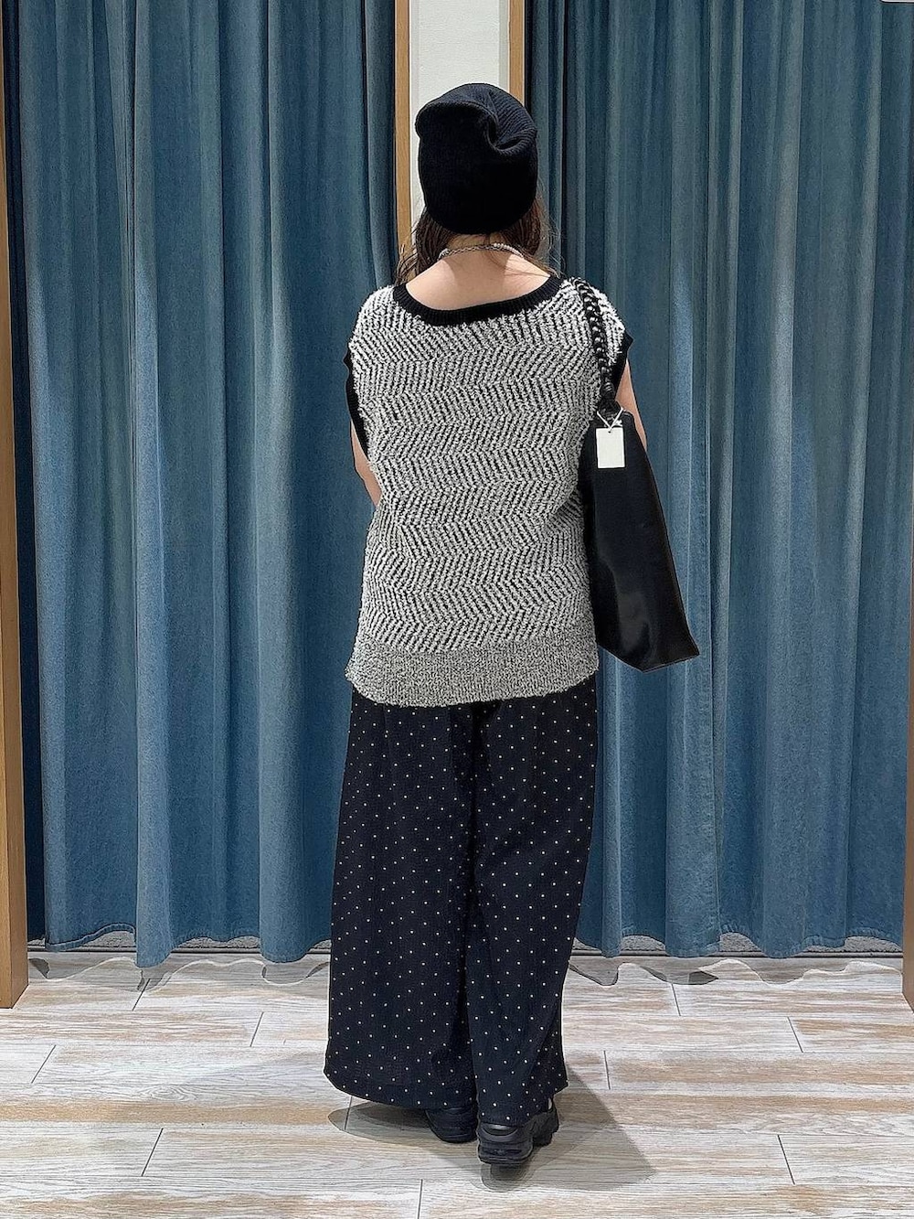 ホワイト系のニット/セーター、ブラック系のトートバッグ、ブラック系のニットキャップ/ビーニーを着用したレディースの夏コーディネートの3枚目の写真