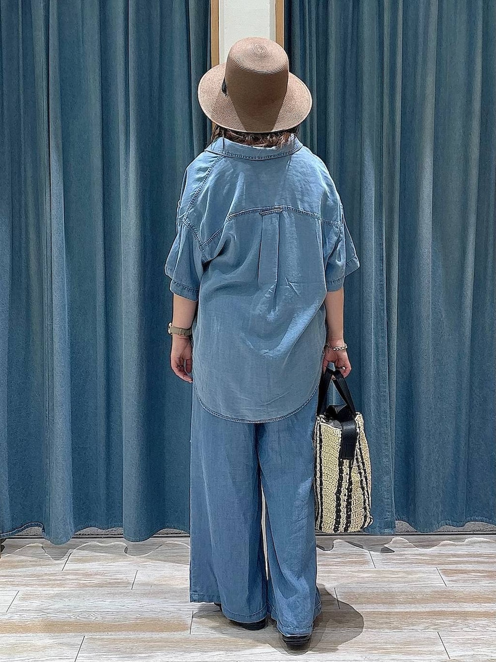 ブルー系のシャツ/ブラウス、ブルー系のデニムパンツ、ベージュ系のトートバッグを着用したレディースの春コーディネートの3枚目の写真