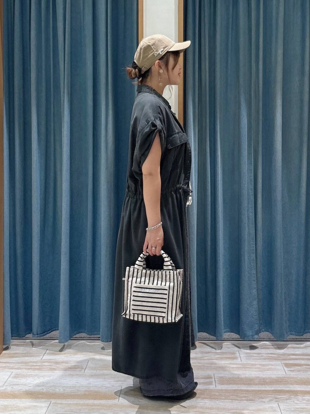 ブラック系のデニムパンツ、ベージュ系のトートバッグ、ブラック系のサンダルを着用したレディースの夏コーディネートの2枚目の写真