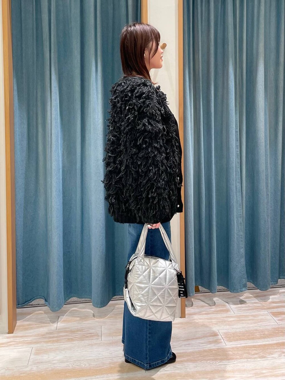 ブラック系のブーツ、レッド系のTシャツ/カットソー、シルバー系のトートバッグを着用したレディースの冬コーディネートの2枚目の写真