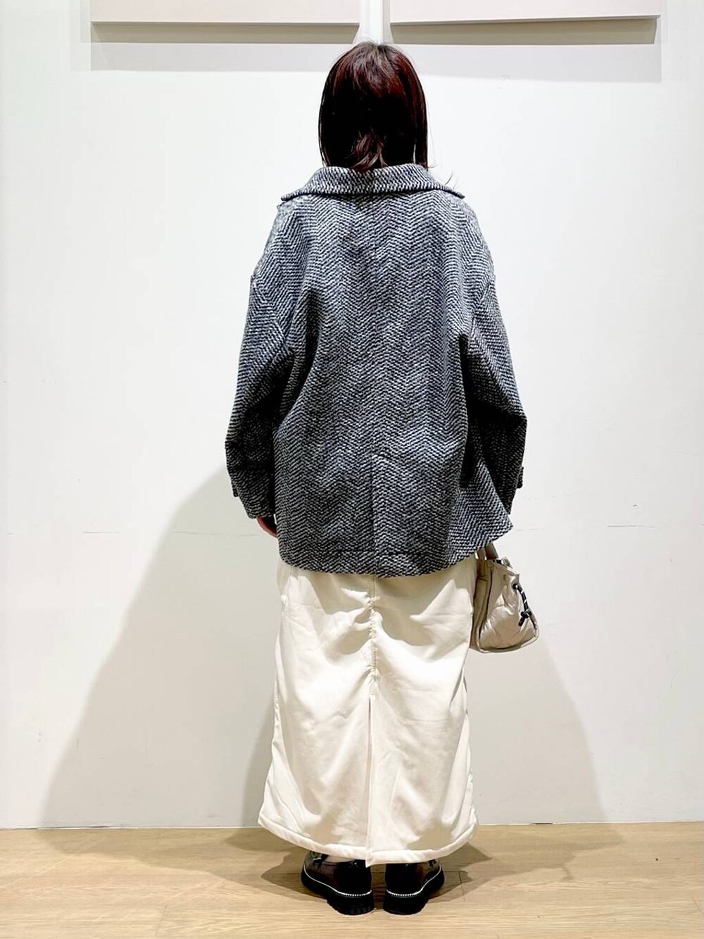 ホワイト系のショルダーバッグ、ブラック系のローファー、ホワイト系のスカートを着用したレディースの秋コーディネートの2枚目の写真