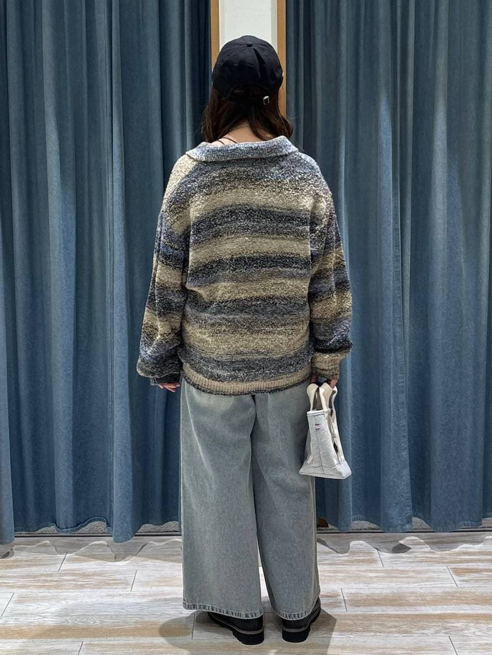 ブラック系のローファー、グレー系のトートバッグ、ブルー系のデニムパンツを着用したレディースの冬コーディネートの3枚目の写真