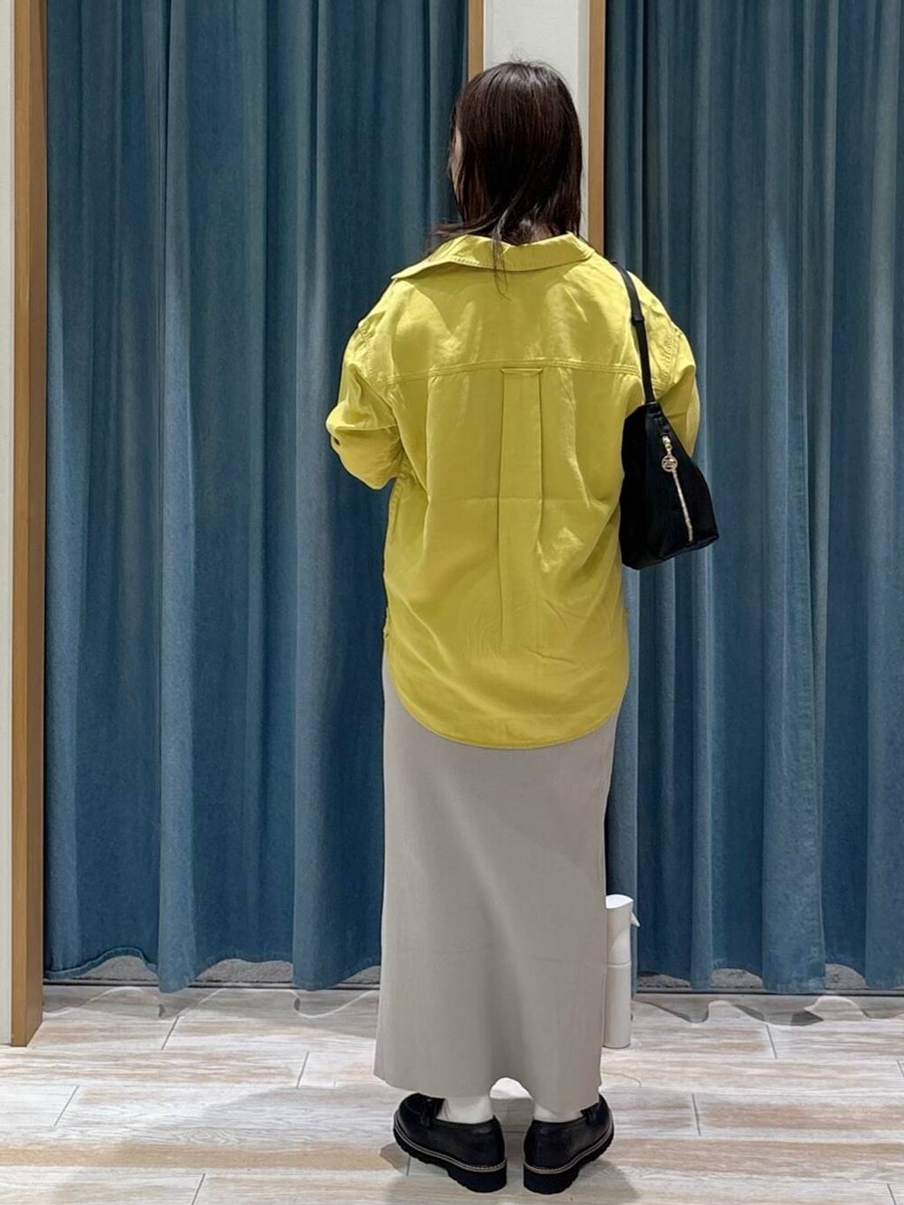 ブラック系のキャミソール、イエロー系のシャツ/ブラウス、ブラック系のローファーを着用したレディースの秋コーディネートの3枚目の写真