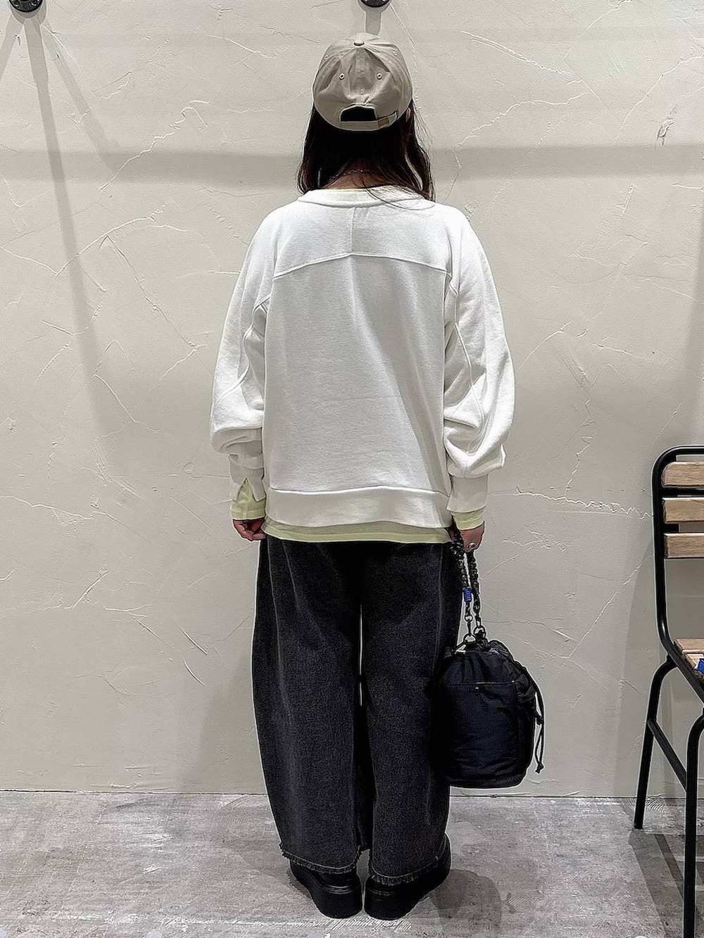 ブラック系のブーツ、ブラック系のショルダーバッグ、ブラック系のデニムパンツを着用したレディースの冬コーディネートの3枚目の写真