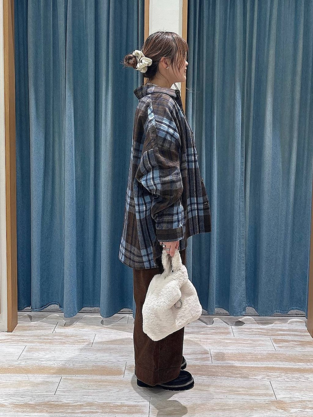 ブラウン系のその他パンツ、ベージュ系のハンドバッグ、ホワイト系のベストを着用したレディースの秋コーディネートの2枚目の写真