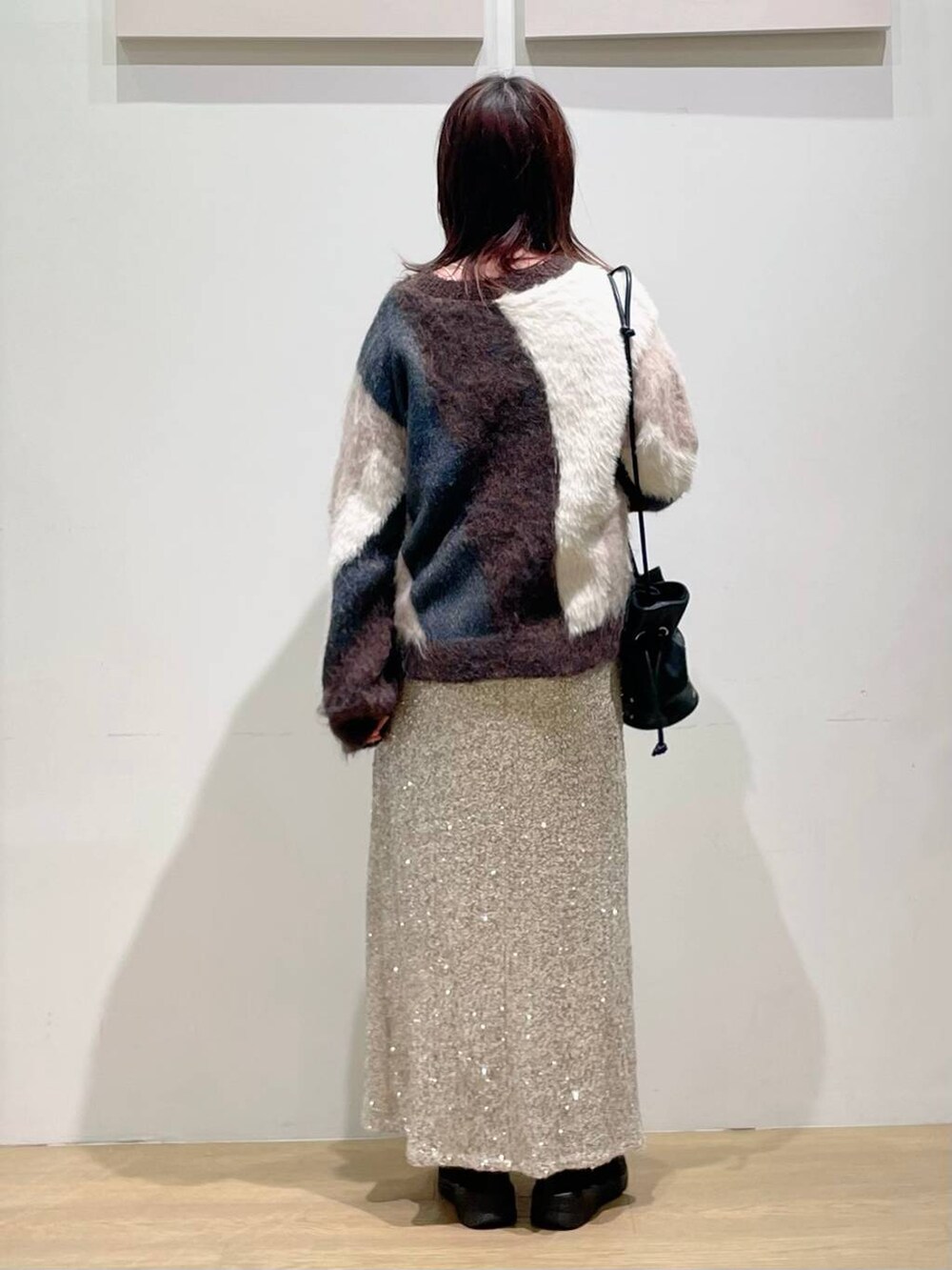 ブラック系のショルダーバッグ、ブラック系のブーツ、ブラウン系のニット/セーターを着用したレディースの秋コーディネートの3枚目の写真