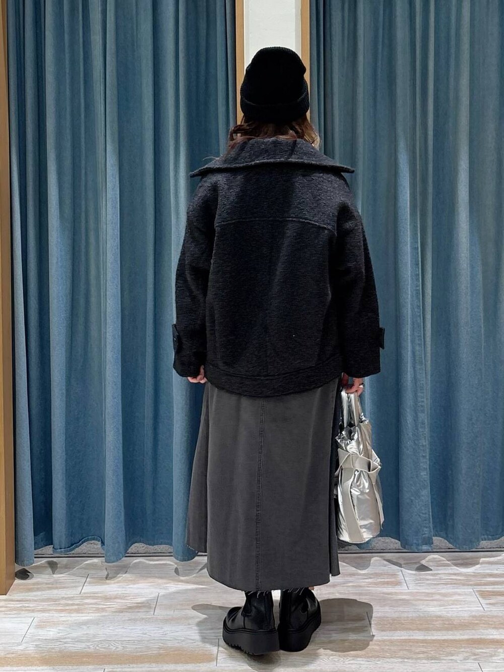 シルバー系のトートバッグ、ブラック系のブーツ、グレー系のその他アウターを着用したレディースの秋コーディネートの3枚目の写真