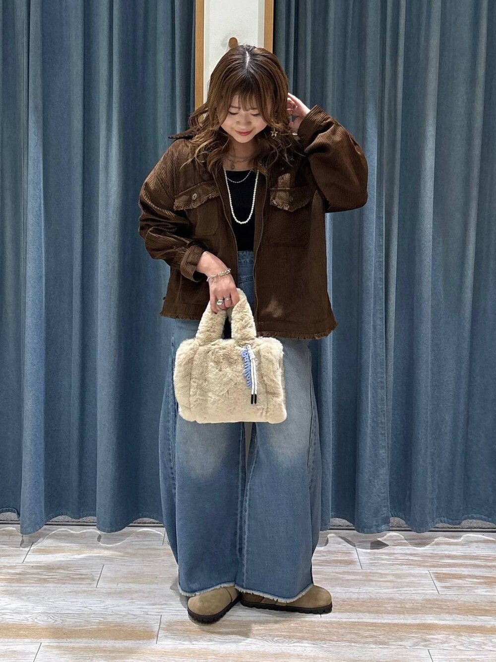 ブラウン系のブルゾン、ベージュ系のその他シューズ、ブルー系のデニムパンツを着用したレディースの秋コーディネートの4枚目の写真