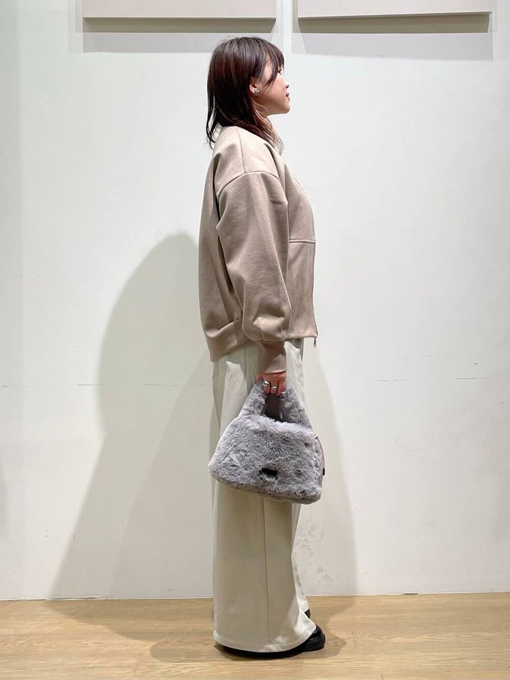 ブラウン系のブルゾン、ホワイト系のTシャツ/カットソー、ホワイト系のベストを着用したレディースの秋コーディネートの2枚目の写真