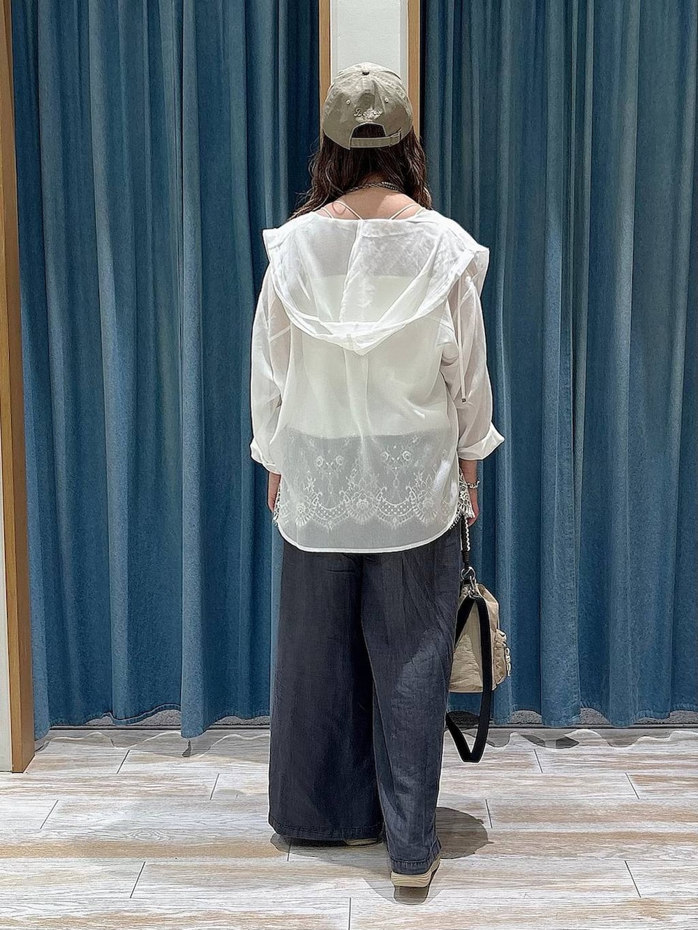 ブラック系のデニムパンツ、ゴールド系のサンダル、ベージュ系のショルダーバッグを着用したレディースの春コーディネートの3枚目の写真