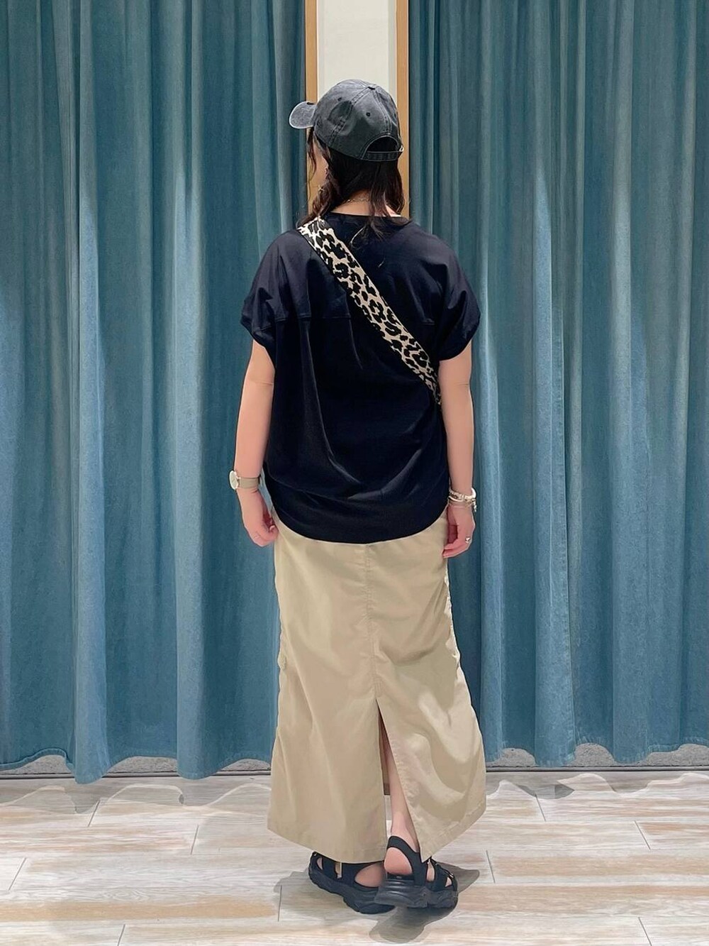 ブラック系のTシャツ/カットソー、ベージュ系のスカート、ブラック系のサンダルを着用したレディースの春コーディネートの3枚目の写真