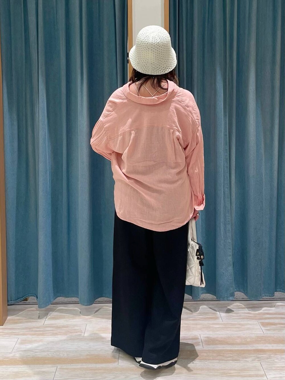 ホワイト系のキャミソール、ブラック系のサロペット/オーバーオール、ホワイト系のハンドバッグを着用したレディースの春コーディネートの3枚目の写真