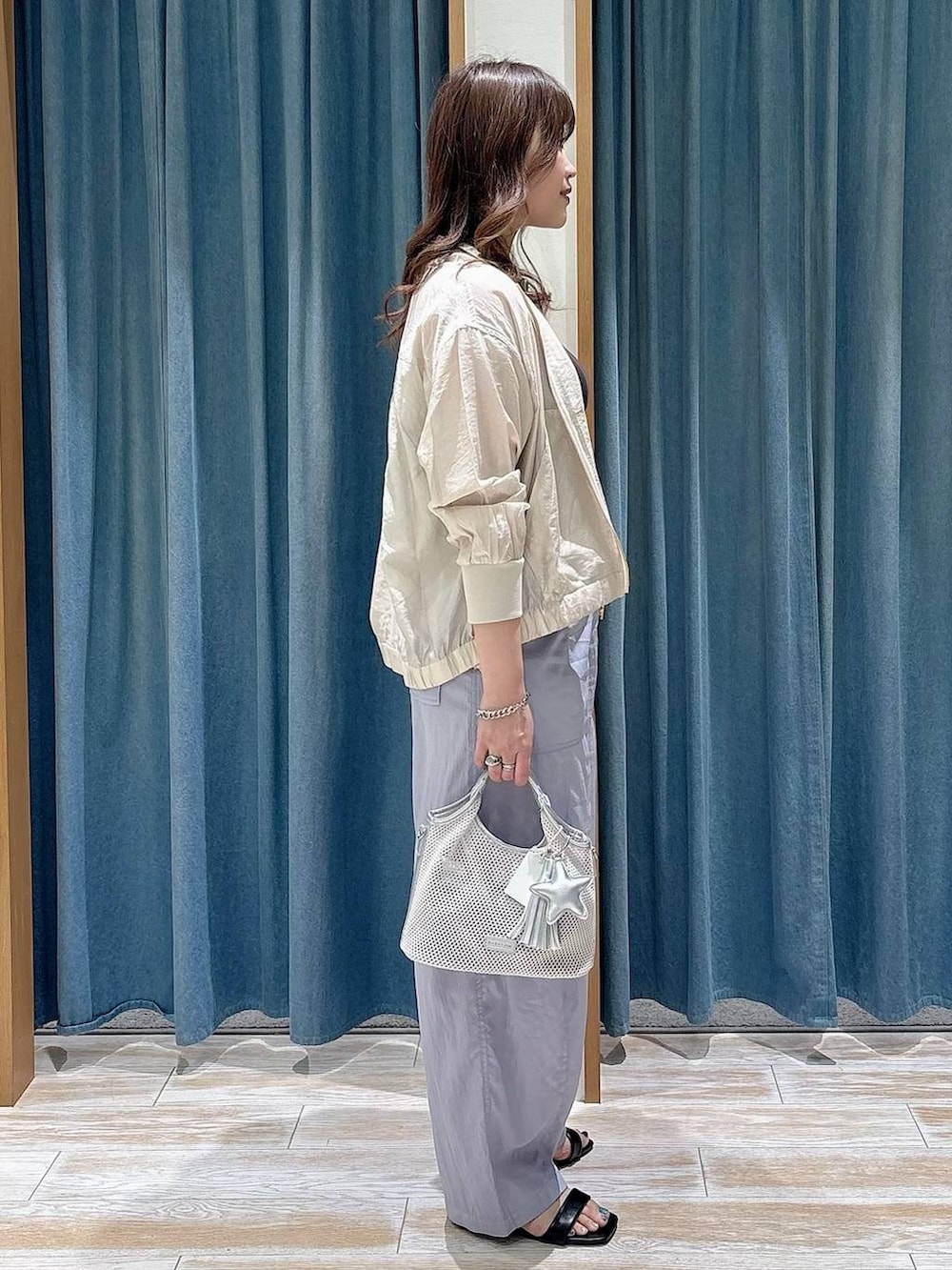 グレー系のショルダーバッグ、ホワイト系のブルゾン、パープル系のその他パンツを着用したレディースの春コーディネートの2枚目の写真