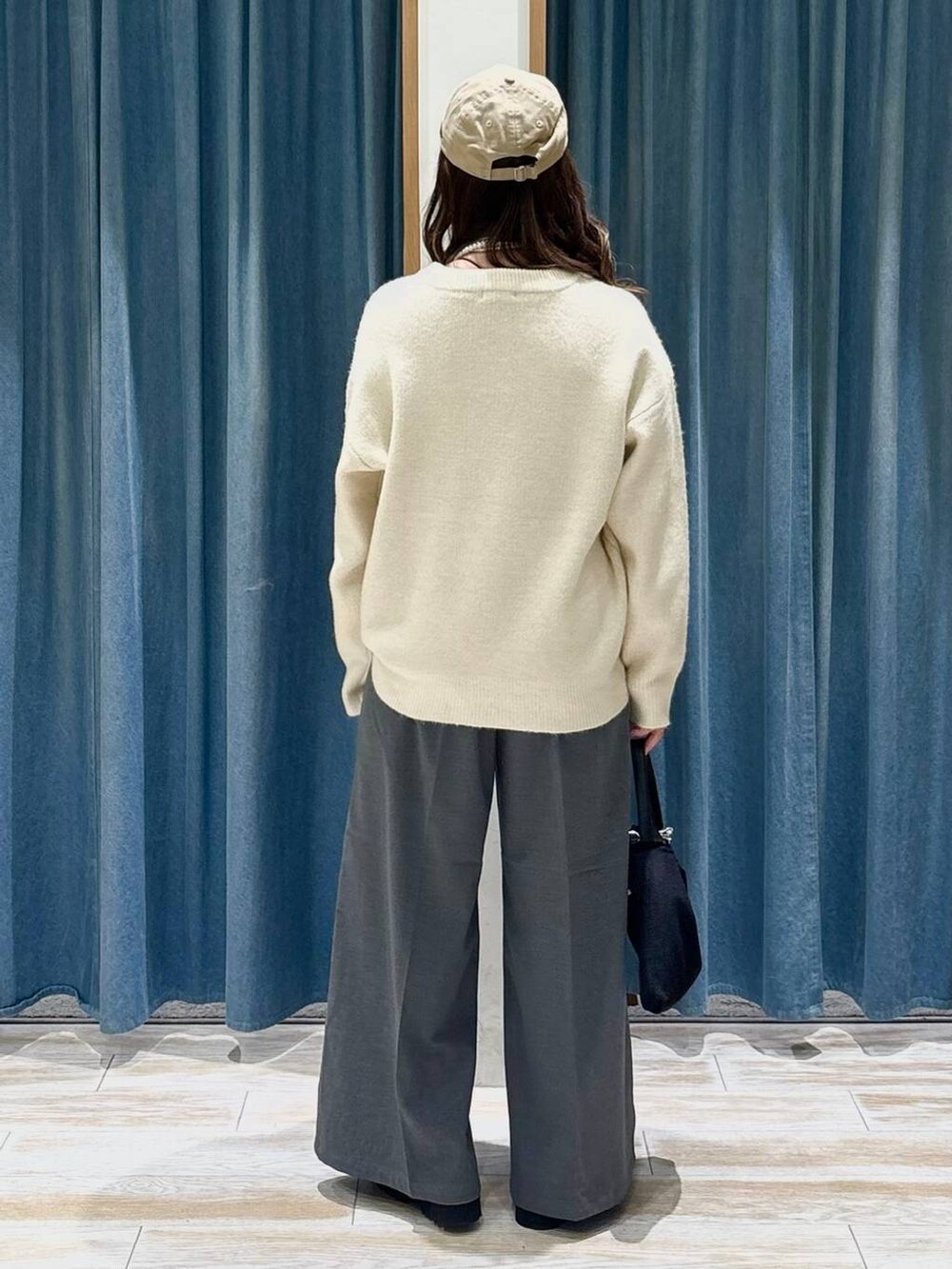 グレー系のその他パンツ、ブラック系のローファー、ホワイト系のニット/セーターを着用したレディースの秋コーディネートの3枚目の写真